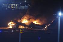 Hořící letadlo společnosti Japan Airlines na ranveji tokijského letiště Haneda