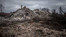 Demoliční práce na bytových domech, zničených ruskými leteckými údery v březnu 2022, 24. února 2023, Hostomel, Ukrajina.