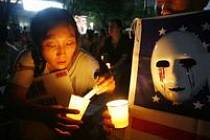 Korejka zapaluje v soulu svíci na demonstraci proti válce a za osvobození korejských rukojmích.