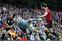 Sergio Agüero z Manchesteru City (vlevo) se poroučí k zemi před Daleyem Blindem z Manchesteru United.