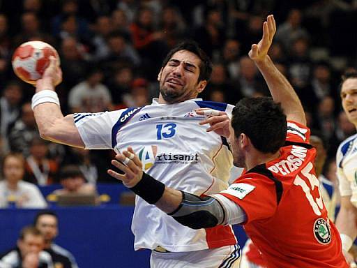 Francouzský házenkář Nikola Karabatic (vlevo) se prosazuje před bránícího Alexandera Peterssona z Islandu.