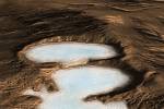 Umělecká představa ukazuje, co odhalila sonda Mars  Reconnaissance  Orbiter.  Jsou to obrovité ledovce zmrzlé vody, kryté vrstvou kamenné drti. Jsou věší, než veškerý led, který byl na rudé planetě dosud objeven.