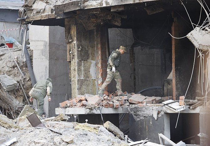 Ukrajinští vojáci v troskách budovy, kterou zasáhl raketový útok na Kyjev