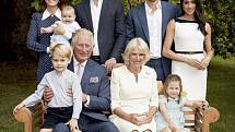 Britský princ Charles (v popředí) se svou manželkou Camillou a vnoučaty princem Georgem a princeznou Charlotte. V horní řadě stojí za ním jeho syn William s manželkou Kate a vnoučetem Louisem a na pravé straně syn Harry s manželkou Meghan.