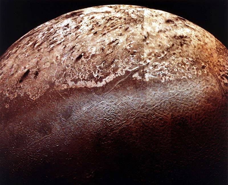 Měsíce Neptunu Triton, jak ho při průletu zachytil Voyager 2.