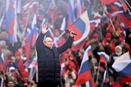 Ruský prezident Vladimir Putin zdraví diváky na moskevském stadionu Lužniki, kde asi 80 tisíc Moskvanů slavilo výročí připojení anektovaného ukrajinského poloostrova Krym k Rusku.