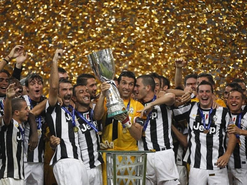 Brankář Juventusu Gianluigi Buffon (uprostřed) s trofejí pro vítěze italského Superpoháru.