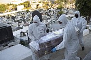 Zaměstnanci hřbitova v ochranných oblecích nesou 7. srpna 2020 rakev s ostatky ženy na hřbitově v brazilském Nova Iguacu.