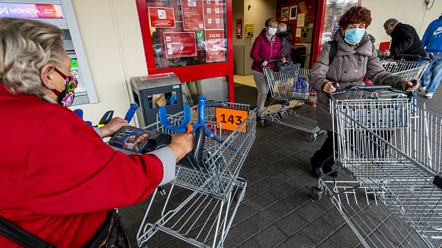 Zákazníci s očíslovanými nákupními vozíky 18. listopadu 2020 u vchodu do hypermarketu v Ústí nad Labem. Od téhož dne platí pro provoz obchodů nová pravidla. Každý zákazník musí mít pro sebe při nákupu plochu 15 metrů čtverečních.