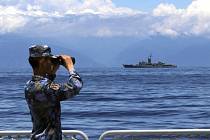 Čínský voják sleduje dalekohledem tchajwanskou fregatu během cvičení ve vodách kolem Tchaj-wanu, 5. srpna 2022
