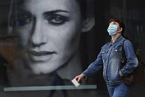Žena v ochranné roušce proti koronaviru u obchodního centra.