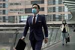 Muž v ochranné masce  prochází 12. února 2020 po ulici v centrální obchodní čtvrti v Hongkongu