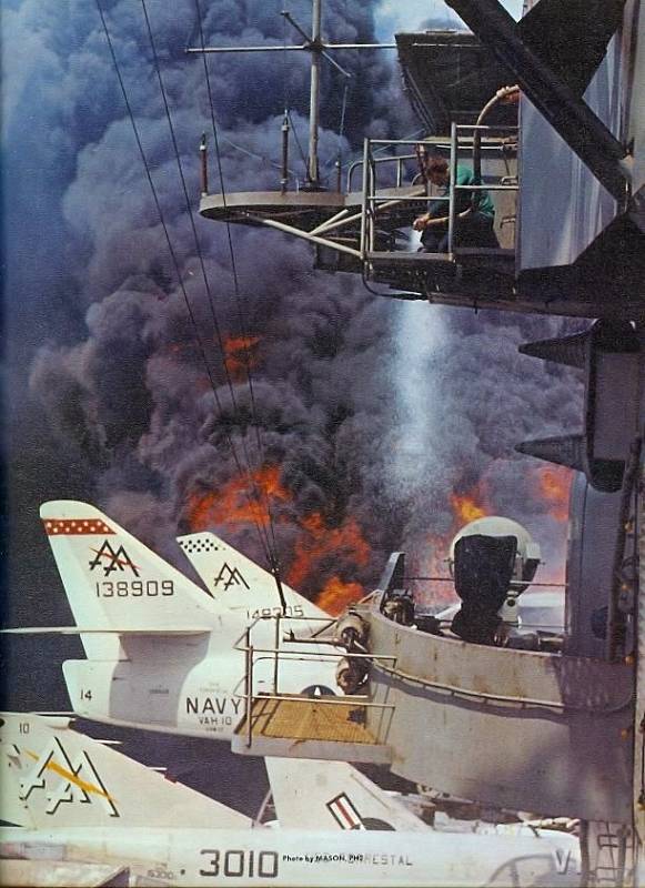 Další snímek ničivého požáru na palubě Forrestalu zachycuje i člena posádky držícího požární hadici