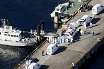 Zdravotníci v ochranných oblecích kontrolují cestující z výletní lodi Diamond Princess v přístavu v Jokohamě.