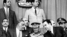 Kaddáfí na arabském summitu v Libyi v roce 1969, krátce po zářijové revoluci, která svrhla krále Idrise. Kaddáfí sedí v uniformě uprostřed s egyptským prezidentem Násirem (vlevo) a syrským presidentem al-Atasím (vpravo)