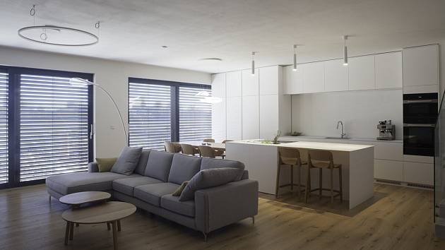 Prostor kuchyně a obývacího pokoje má plochu 55 metrů čtverečních. V bílém laku je kuchyňská linka i varný ostrůvek.