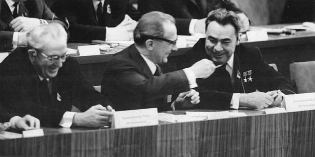 Stranický sjezd východoněmecké komunistické strany SED v roce 1967. Vpravo tehdejší generální tajemník ÚV KSSS Leonid Brežněv v rozhovoru s členem politbyra Ústředního výboru SED Erichem Honeckerem. Usmívající se muž vlevo je Jurij Andropov