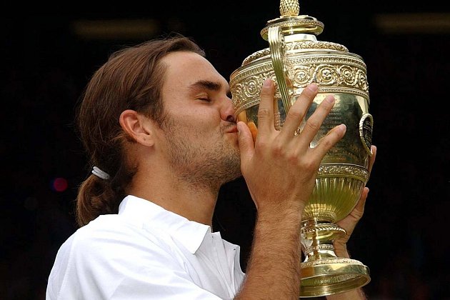 Roger Federer líbá svou první grandslamovou trofej.