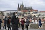 Turistka s rouškou prochází 29. ledna 2020 po Karlově mostě v Praze