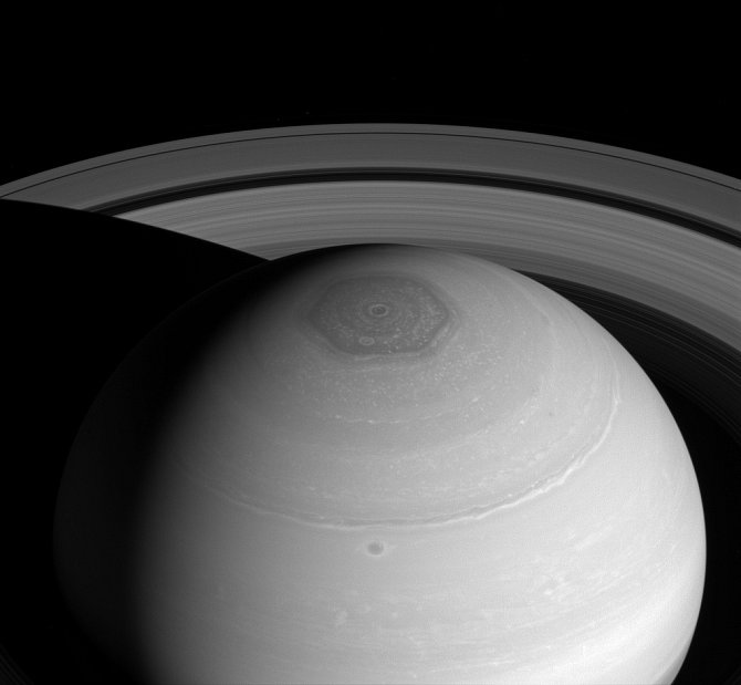 Snímek z vesmírné sondy Cassini zachycuje hned tři pozoruhodnosti planety Saturn: rozpínající se prstence, severní polární vír a hexagonální bouři, širší než dvě Země
