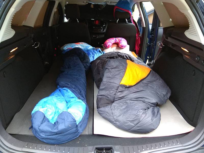 Spacáky v kufru jsou připraveny na přespání v autě.