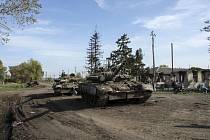 Opuštěné ruské tanky stojí na silnici v osvobozeném ukrajinském městě Kupjansk, 1. října 2022.