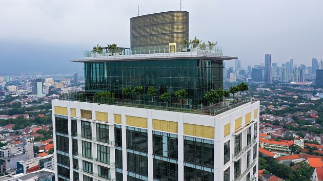 Střešní dům na střešní terase výškového bytového domu v Jakartě. V pozadí panorama města.