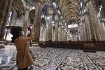 Turista s rouškou fotí interiér gotické katedrály Narození Panny Marie v Miláně (italsky Duomo di Milano)