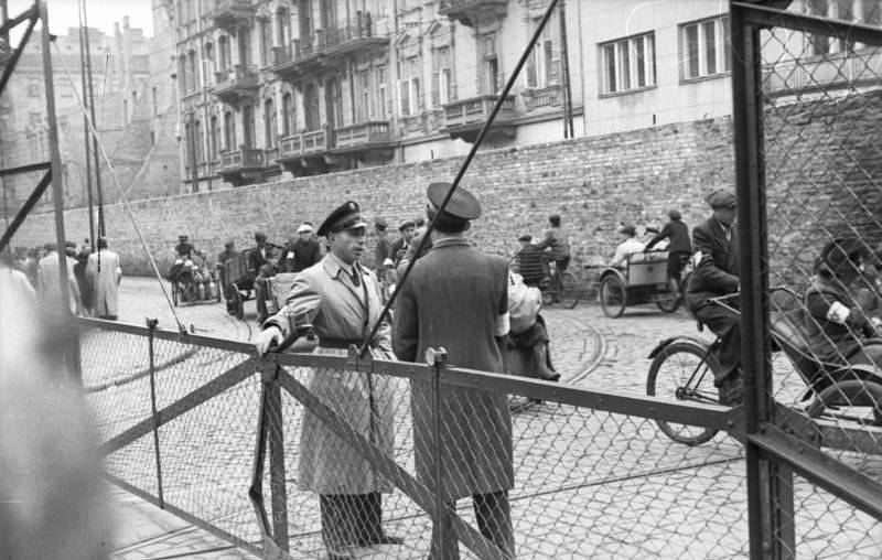 "Židovská policie" hlídá vstup do varšavského ghetta, červen 1942