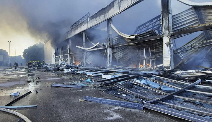 Na fotografii z videa státní pohotovostní služby Ukrajiny zasahují hasiči u nákupního centra v Kremenčuku po raketovém útoku, 27. června 2022.