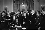 Prezident Lyndon B. Johnson podepisuje 2. července 1964 zákon o občanských právech. Přihlíží Martin Luther King Jr. a další