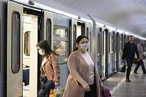 Lidé s rouškami v metru v Moskvě