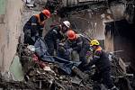 Záchranáři zasahují v troskách obytného domu v Dnipru na východě Ukrajiny 15. ledna 2023 po sobotním ruském raketovém útoku.
