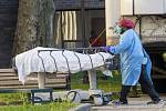 Zdravotník s tělem zemřelého ve zdravotnickém centru v newyorském Brooklynu, 8. dubna 2020