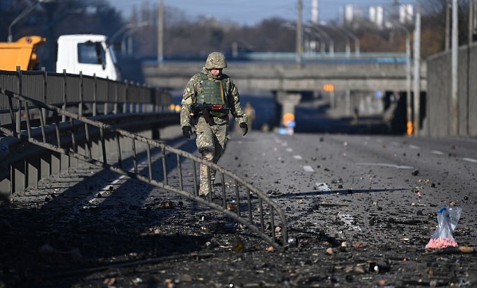 Ukrajinský voják prochází místem zasaženým během bojů o Kyjev. Ilustrační foto.