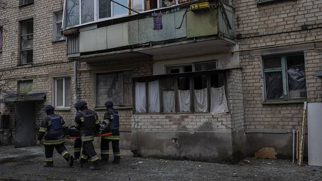 Záchranáři nesou tělo ženy, která zahynula při ruském ostřelování ukrajinského Chersonu, 25. listopadu 2022