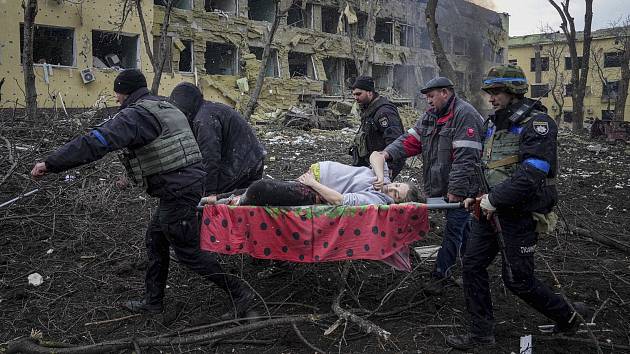Válka na Ukrajině (Mariupol, 9. března 2022). Ukrajinští záchranáři a dobrovolníci přenášejí zraněnou těhotnou ženu po útoku na nemocnici. Dítě se narodilo mrtvé, krátce poté zemřela i matka