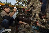 Mladí dobrovolníci pomáhají vojákům čistit zbraně konzervačním mazivem poblíž Hadrutu v Náhorním Karabachu