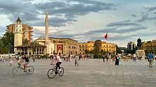 Skanderbegovo náměstí ilustruje albánskou historii. V pozadí domy postavené Mussolinim za italské okupace doplňuje mešita z dob turecké nadvlády a pravoslavný chrám. V pozadí pak moderní výškové budovy. Socha Skanderbega vystřídala Hodžu, předtím Stalina.