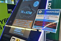 Vkladový bankomat na virtuální měnu s upozorněním policie na podvodné telefonní hovory.