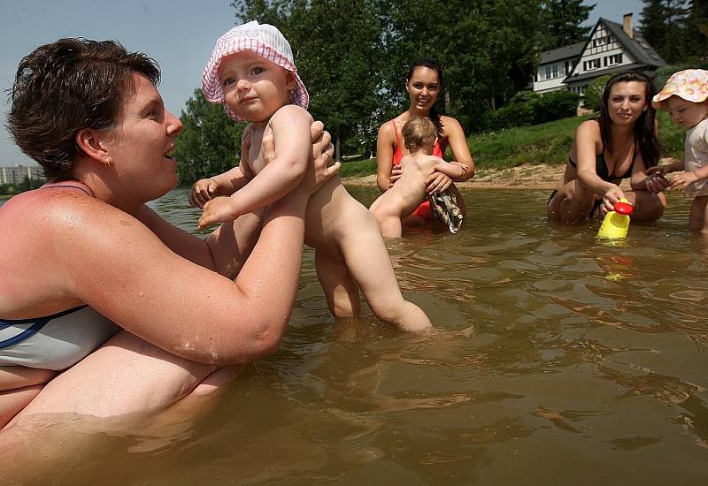 Na jablonecké přehradě se díky teplému počasí již zaplňují pláže. Na snímku Petra Břešťáková s dcerou Sárou.