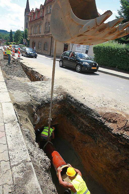 BUDOVÁNÍ KANALIZACE. Na dvanáct set metrů dlouhém úseku silnice I/10 ve Velkých Hamrech v současné době budují splaškovou kanalizaci. Dopravu na zúžené silnici kyvadlově řídí semafory. Část úseku bude možná v srpnu uzavřena úplně.