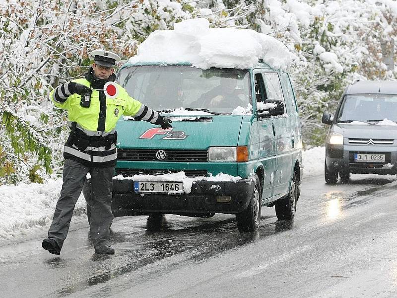 Pátek odpoledne. Kalamitní stav na Jablonecku. U přehrady řídila policie kyvadlovou dopravu tak, aby mohli silničáři postupně odstraňovat stromy hrozící pádem do vozovky.