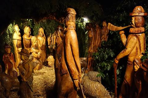 Na soukromé zahradě na Skřivánčí stezce stojí opět nasvícený betlém ve stylu velkých dřevěných vyřezávaných soch.