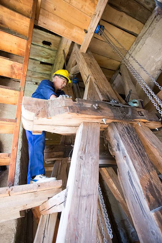 Zvonaře Petr Rudolf Manoušek (se žlutou helmou) dohlíží na instalaci zvonů ve věži kostela svatého Václava v Harrachově.