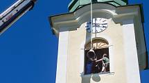 Zvonaře Petr Rudolf Manoušek (se žlutou helmou) dohlíží na instalaci zvonů ve věži kostela svatého Václava v Harrachově.
