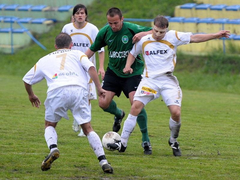 Domácí FC Pěnčín hostil již jistého vítěze soutěže FC Podještědský Český Dub. Na snímku hostující útočník Němec (uprostřed v zeleno černém) se snaží prosadit přes domácí hráče – zády s č. 7 Lukáš Kulhánek, vpravo s maskou Petr Heinenreich.