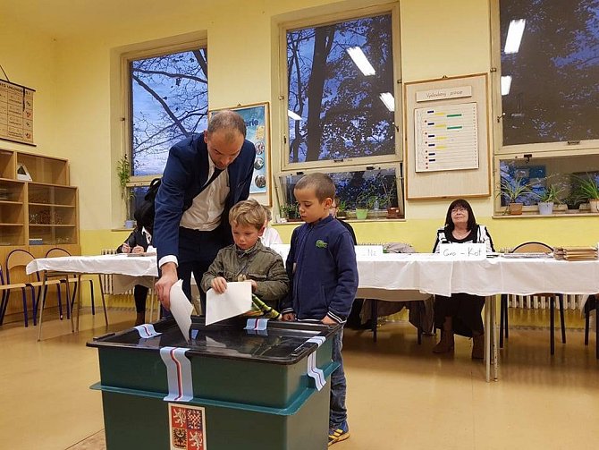 Děti pomáhají svým rodičům volit. 