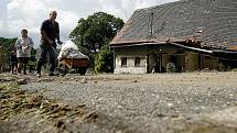 Lidé v zatopených místech potřebují pomoc. Balenou vodu, úklidové prostředky a další nutný materiál. Na snímku pondělní úklid v Heřmanicích.