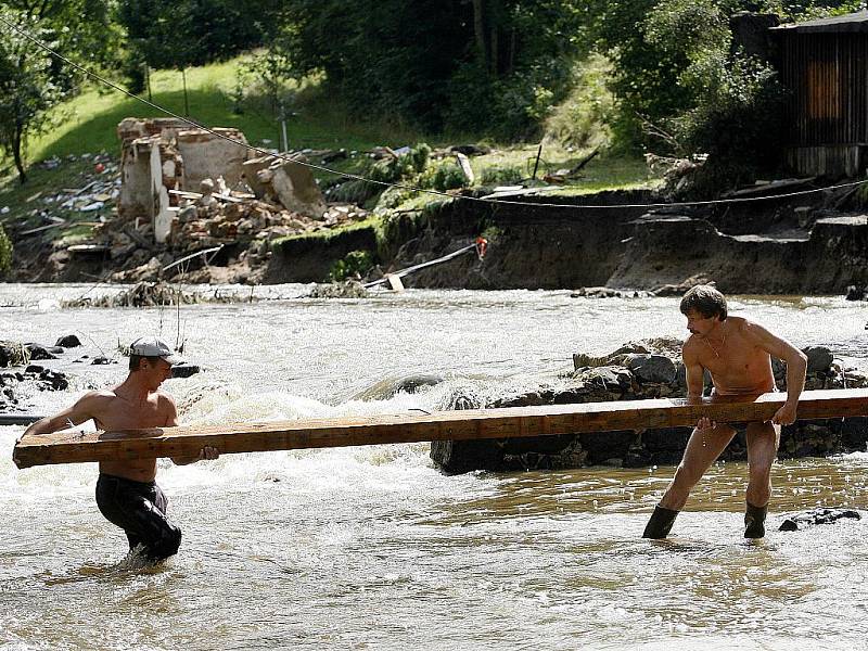 Lidé v zatopených místech potřebují pomoc. Balenou vodu, úklidové prostředky a další nutný materiál. Na snímku pondělní úklid v Heřmanicích.